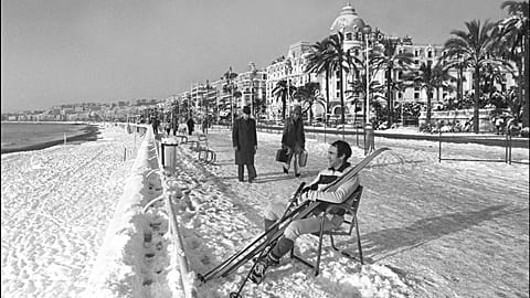 A man takes off his skis to rest at the Promenade des Anglais after  rare heavy snowfall in Nice, France. January 8, 1985
