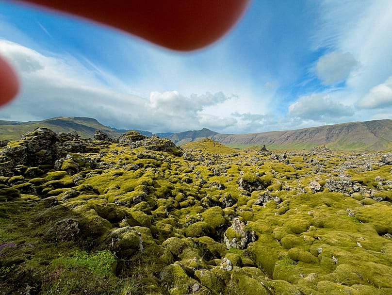 Fotografia do campo de lava Berserkjahraun, na Islândia, de Blanche Mortemard, com os dedos a aparecer na imagem