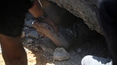 محاولة انتشال جثة صبي من تحت الركام بعد غارة إسرائيلية على خان يونس