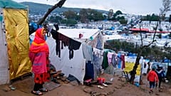 A migrant stands next to their makeshift tent outside the perimeter of the overcrowded Moria refugee camp on Lesbos.