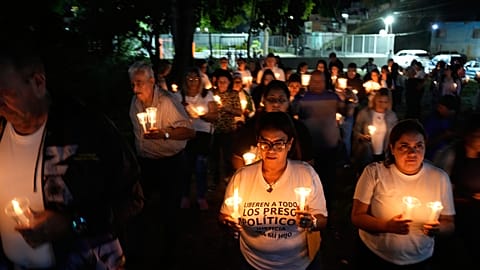 Relatives and friends of political prisoners hold candles asking for the release of their loved ones in front of the Rodeo I prison in Guatire, Venezuela, 9 January 2026.