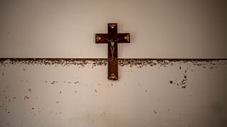 Um crucifixo marca a altura da água numa zona afetada pelas cheias em Paiporta, Valência, a 5 de novembro de 2024.