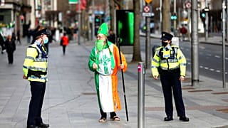 Un hombre disfrazado de San Patricio habla con la policía
