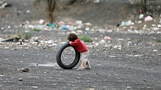 Boy leans on a tyre at a camp for internally displaced people near Sanaa