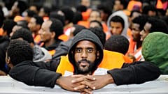 Sub-Saharan migrants stand on an Italian rescue boat in 2014.