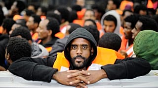 Sub-Saharan migrants stand on an Italian rescue boat in 2014.