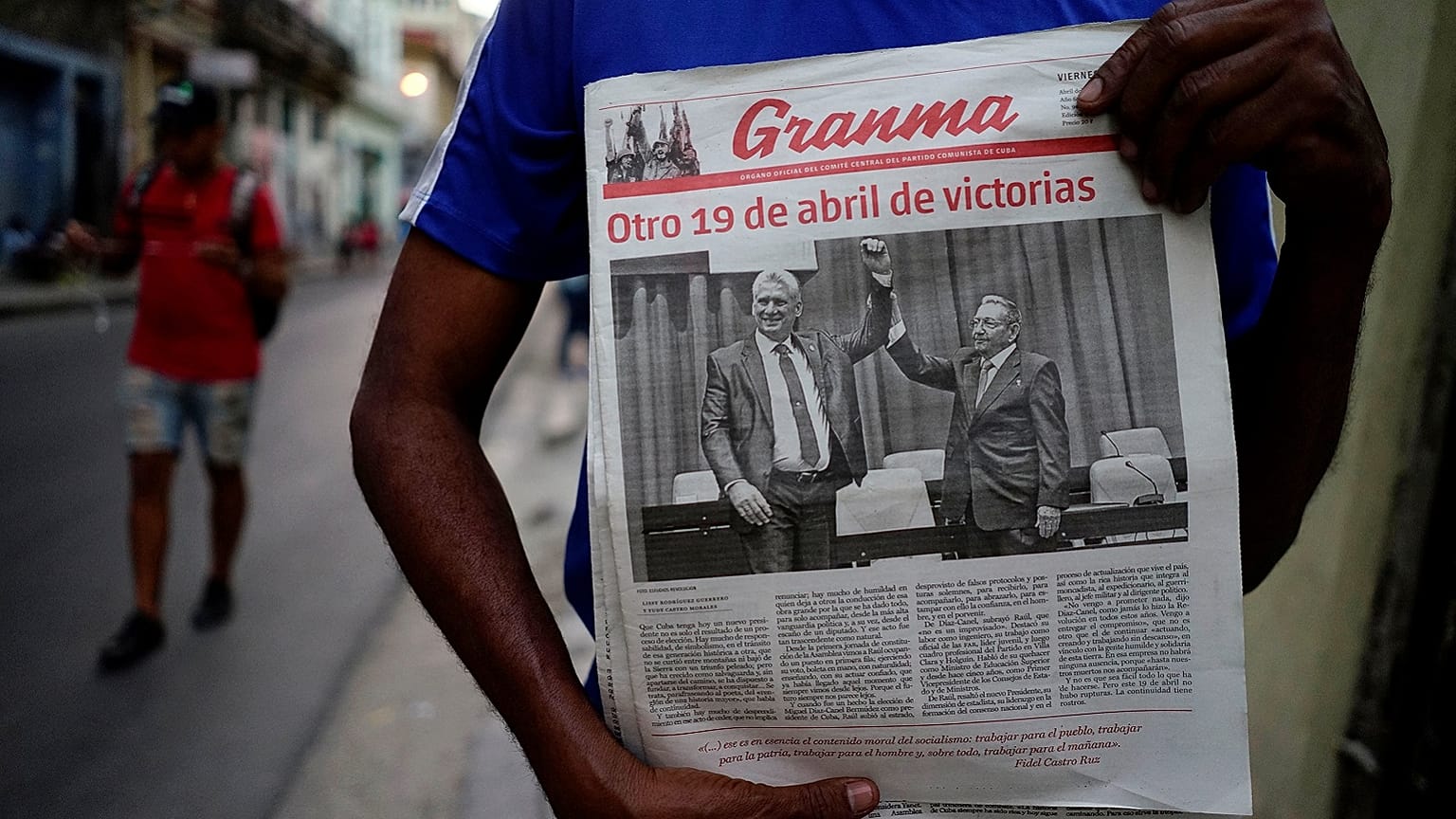 A man holding a newspaper marking the transition of power