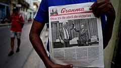 A man holding a newspaper marking the transition of power