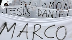 Demonstrators hold canvas with the names of the three film students