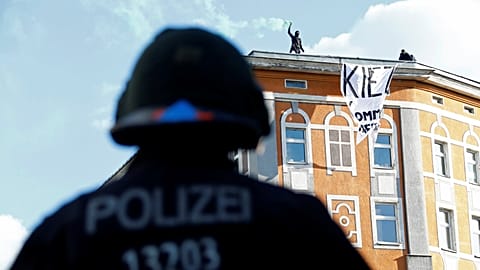 Police look an as protesters use flares ahead of May Day rallies in Berlin