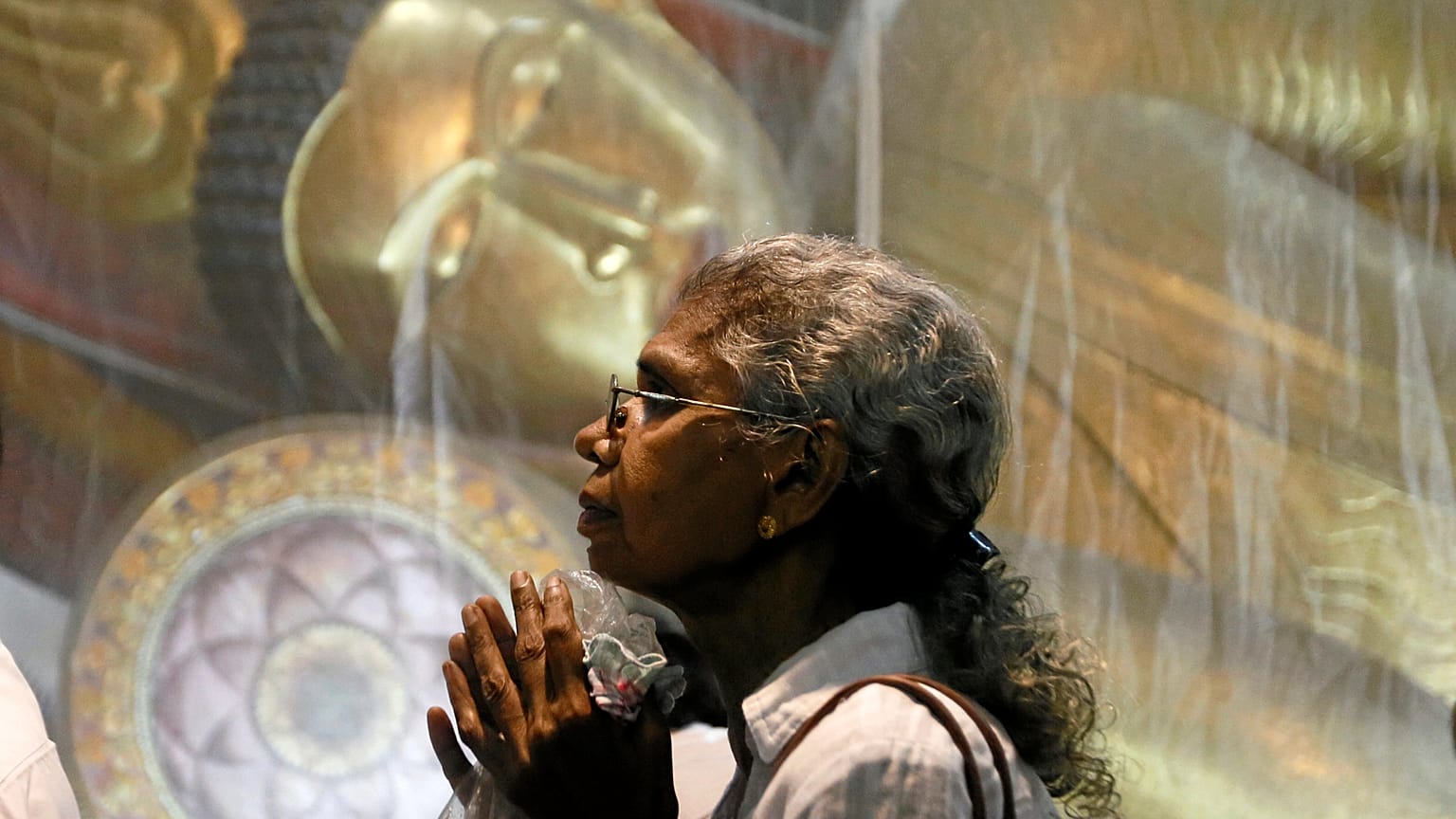 Mulher reza num templo budista do Sri Lanka