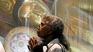 Mulher reza num templo budista do Sri Lanka