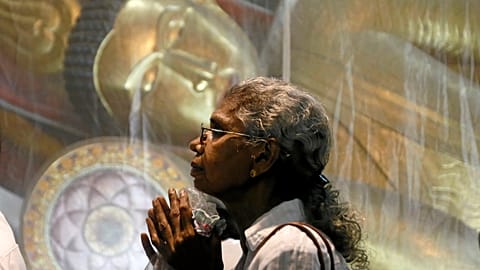 Mulher reza num templo budista do Sri Lanka