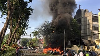 Motorräder brennen vor einer Kirche in Indonesien
