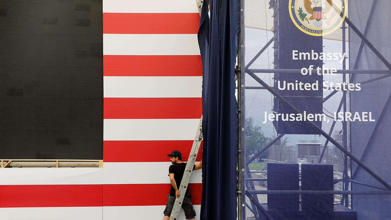 Ein Mann arbeitet vor den Streifen einer USA-Flagge.