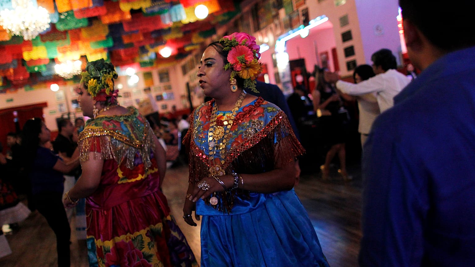 A "muxe", wearing a traditional Zapotec woman's costume, dances during a tr