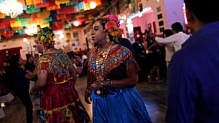 A "muxe", wearing a traditional Zapotec woman's costume, dances during a tr