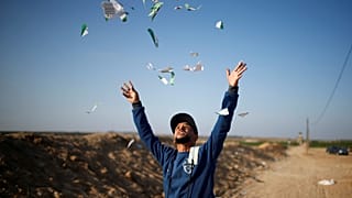 شاب فلسطيني ينثر منشورات مزقها بعد أن ألقاها الجيش الإسرائيلي على قطاع غزة