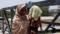 أم تغطي ابنها بمنشفة مبللة لتقيه حر الشمس