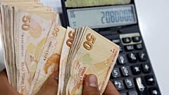 Un cambiavaluta turco conta un fascio di banconote da 50 lire turche