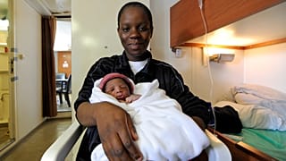 A woman,who just gave birth on board the Aquarius, poses with her newborn 