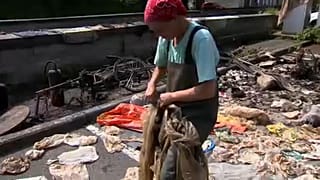 Mulher com plástico retirado do fundo do rio