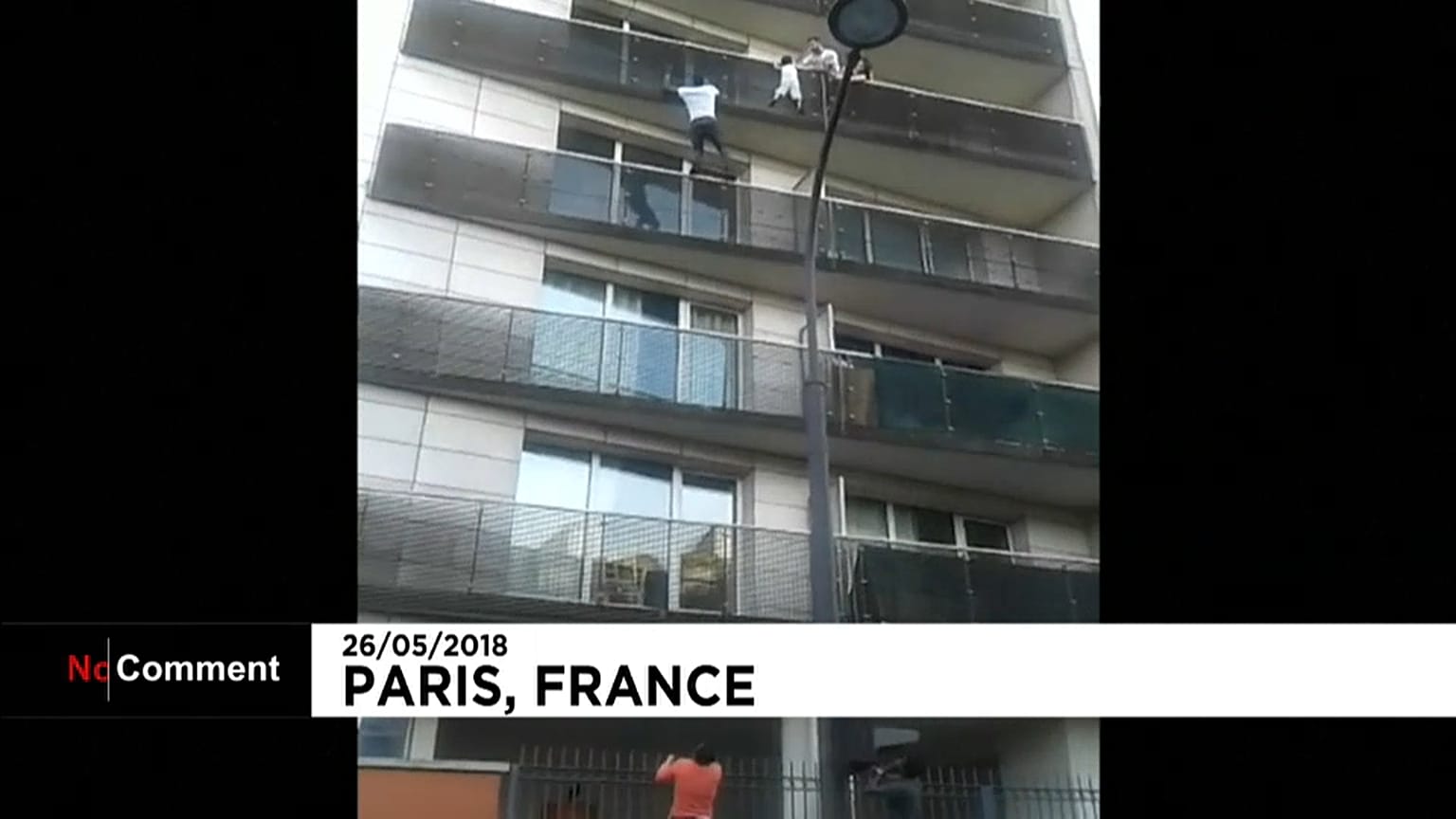 Malian migrant Mamoudou Gassama scales a building to save a young boy
