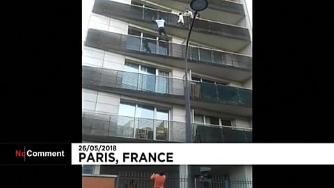 Malian migrant Mamoudou Gassama scales a building to save a young boy