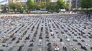 pairs of shoes representing lives lost in Mideast greet EU FMs