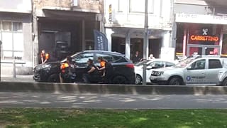 Police officers shelter near the scene of the shooting