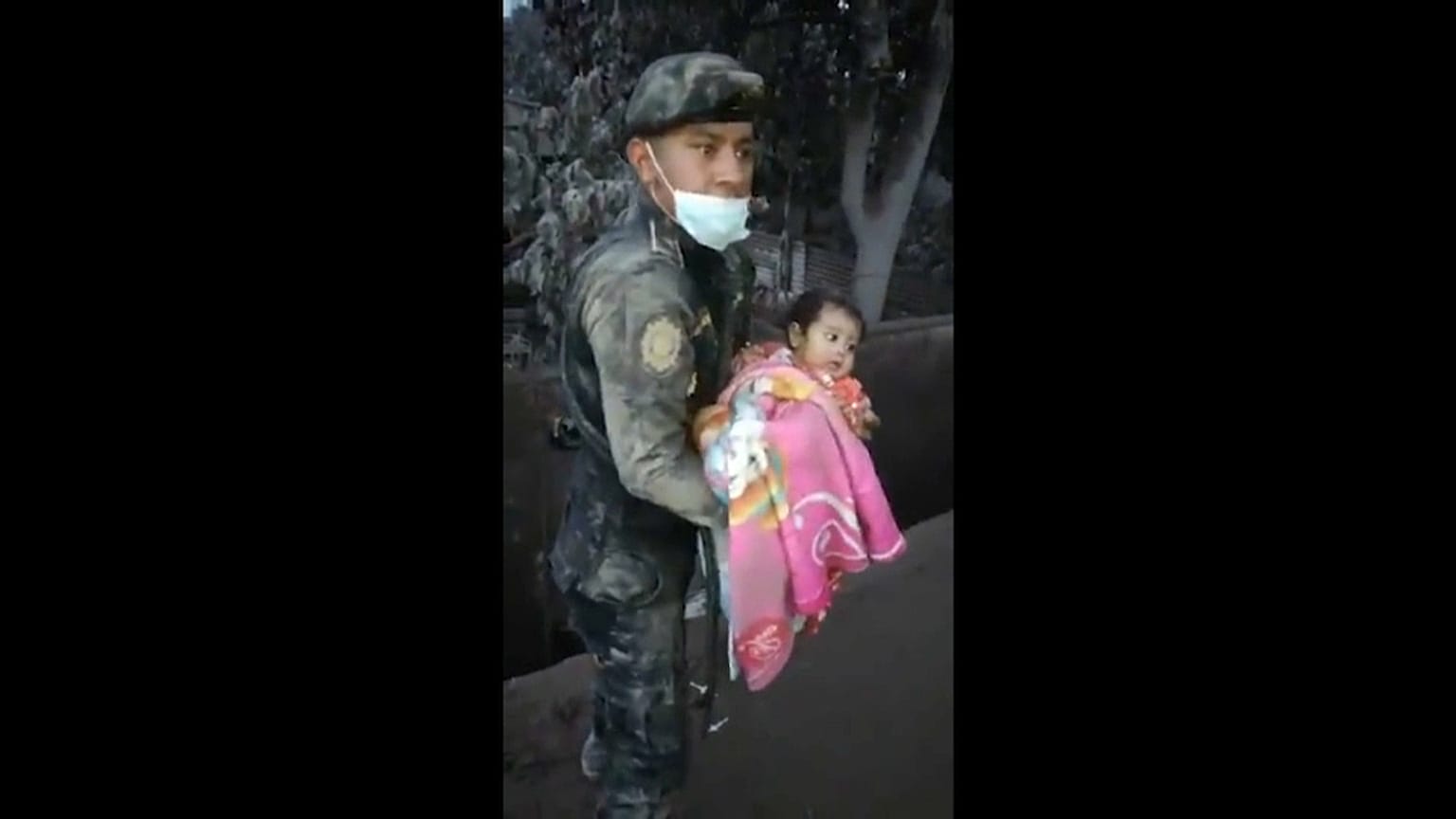 Guatemalan police officer rescuing a baby from the debris