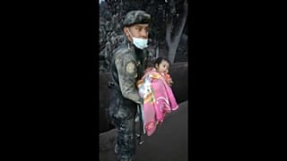 Guatemalan police officer rescuing a baby from the debris