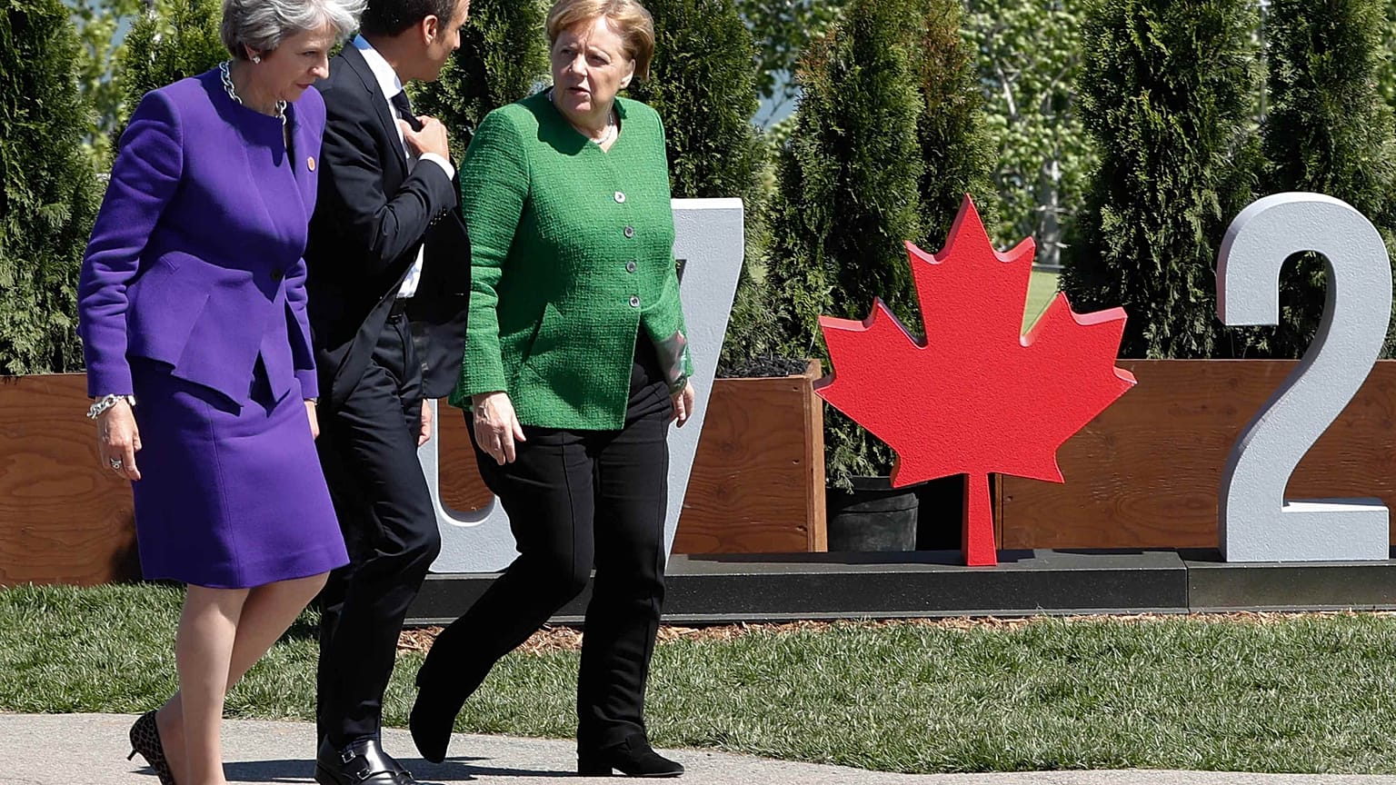 Theresa May (L), Emmanuel Macron and Angela Merkel at the 2018 G7 Summit.