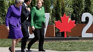 Theresa May (L), Emmanuel Macron and Angela Merkel at the 2018 G7 Summit.