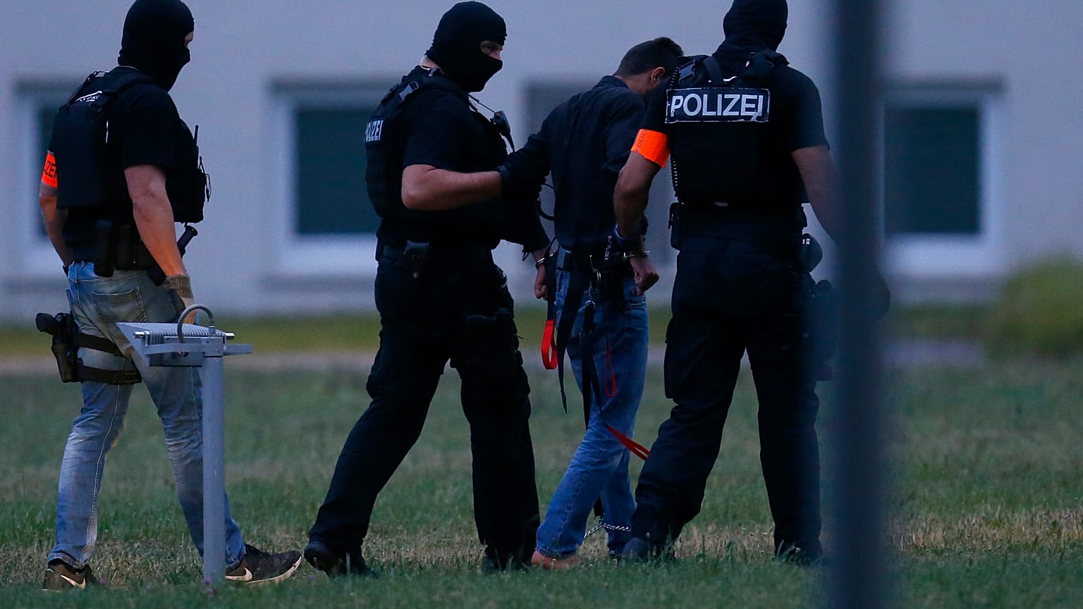 Murder suspect Ali Bashar is led away by police
