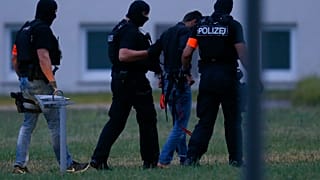 Murder suspect Ali Bashar is led away by police