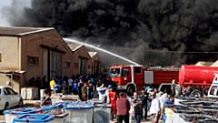 رجال الاطفاء يحاولون إخماد حريق في مخزن لصناديق الاقتراع في بغداد
