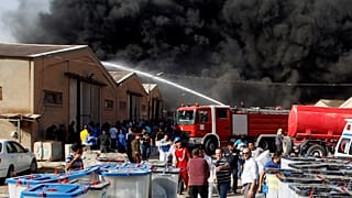 رجال الاطفاء يحاولون إخماد حريق في مخزن لصناديق الاقتراع في بغداد