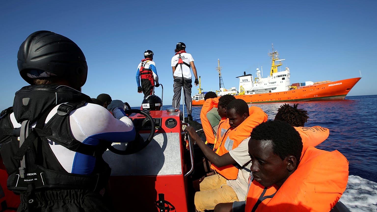 Migrants on a rubber boat are rescued by the SOS Mediterranee