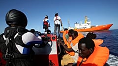 Migrants on a rubber boat are rescued by the SOS Mediterranee
