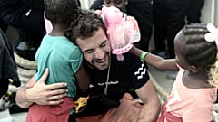 A crew member hugs a migrant child aboard the Aquarius rescue ship