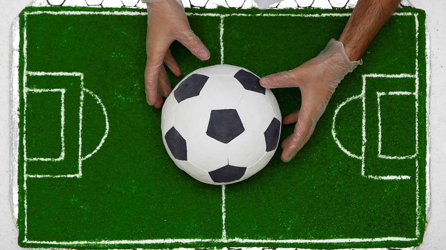 A pastry chef presents a football-shaped cake in Sochi, Russia, 16/06/2018
