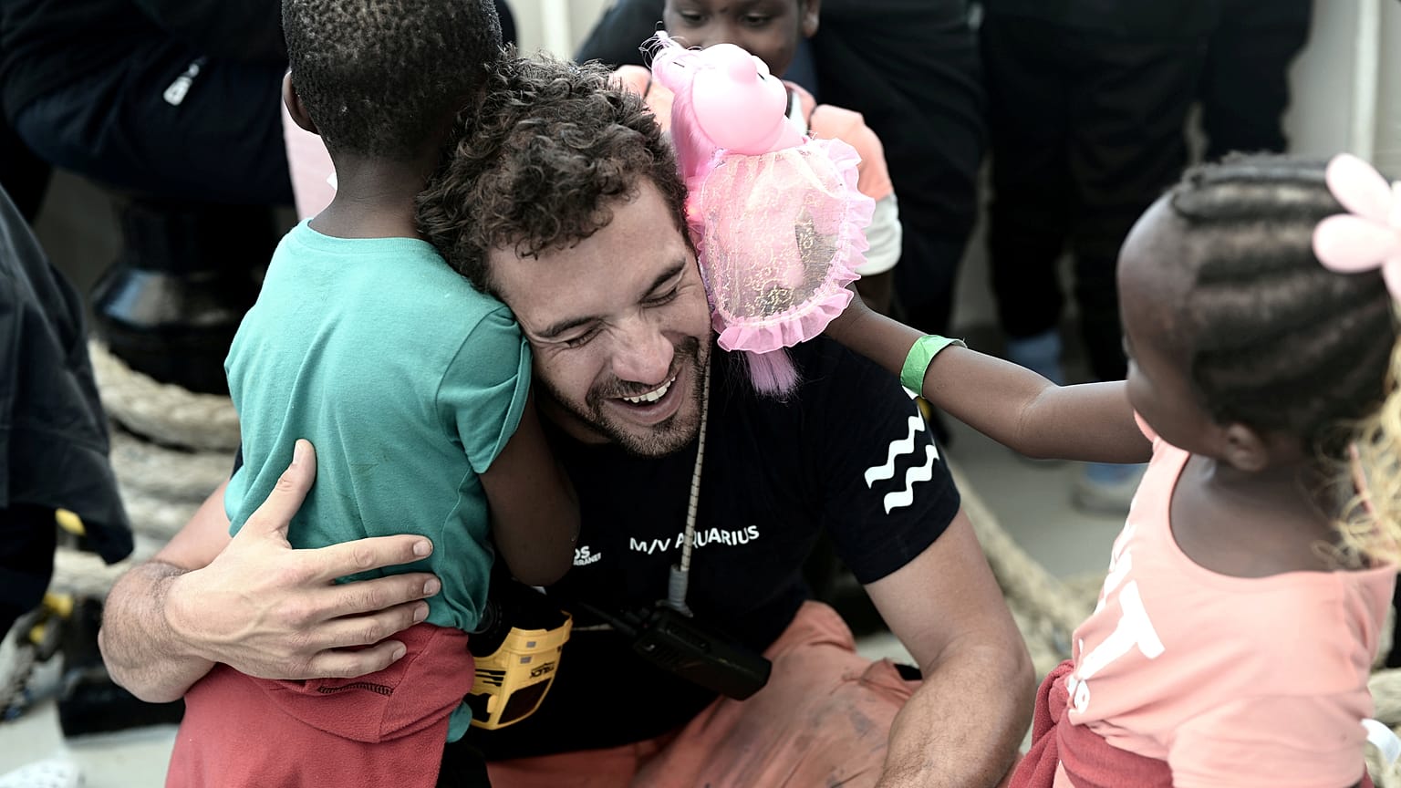 Migrants say goodbye to the crew of the Aquarius
