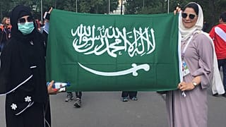 سعوديتان يرفعان علم المملكة خارج استاد لوجنيكي في موسكو
