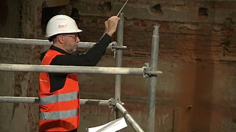 Klassisches Konzert mit Helm auf dem Baugerüst