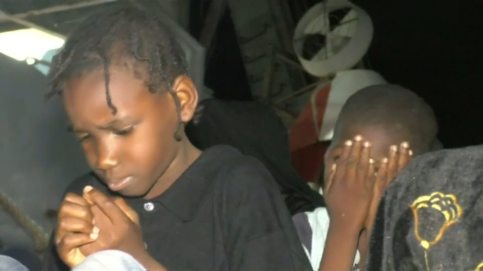 Child migrants sitting on dock in Libya's port of Tripoli
