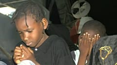 Child migrants sitting on dock in Libya's port of Tripoli