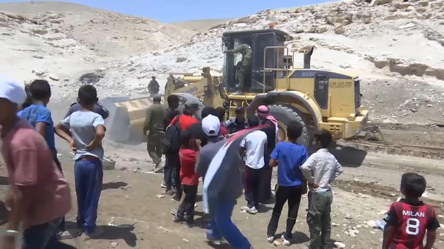 جرافة تزيح الخيام والبيوت الموجودة في المكان
