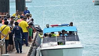 Rescue workers carry a body recovered from the scene