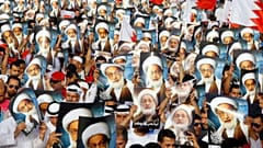 محتجون يحملون صورا لرجل الدين الشيعي البارز آية الله نعيم قاسم 
